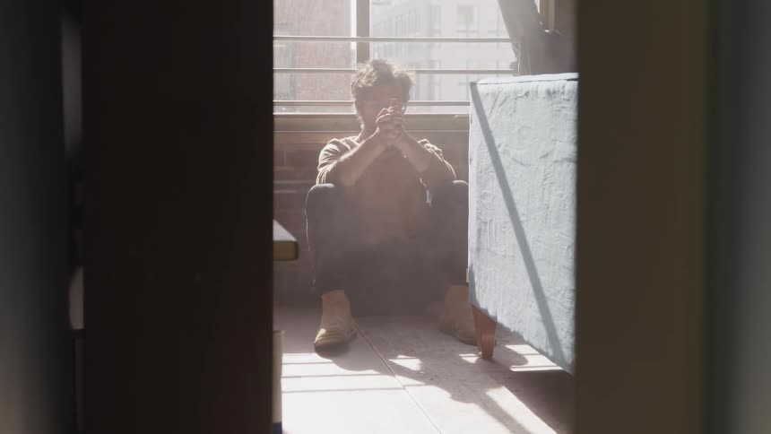 A man is sitting by the window