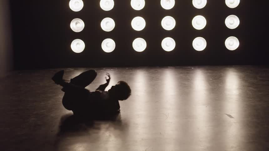A person is breakdancing in front of the lights