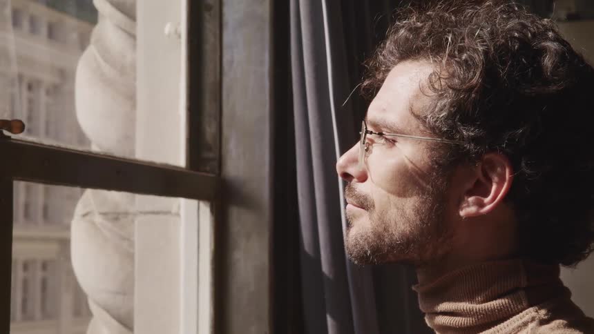 A man is looking out the window