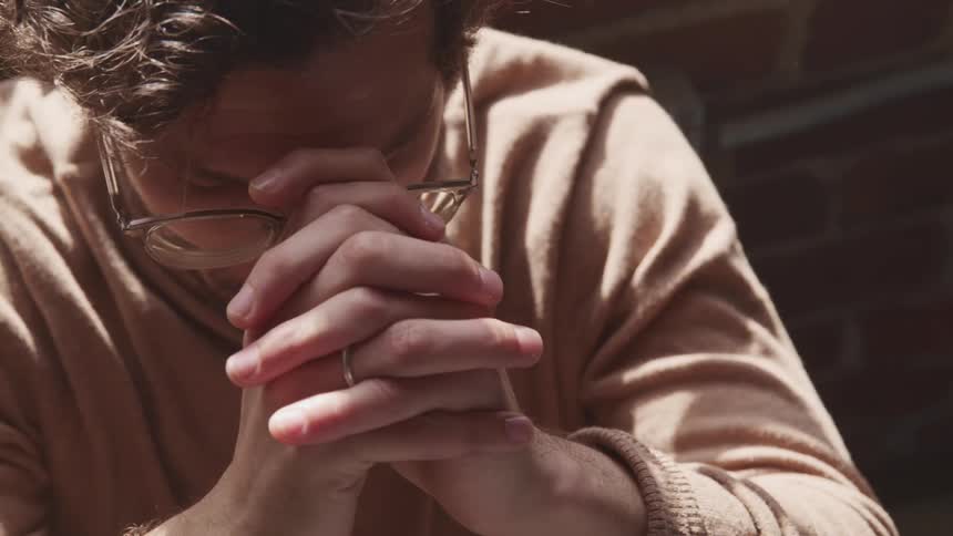 A man puts his head in to his hands and shakes his head