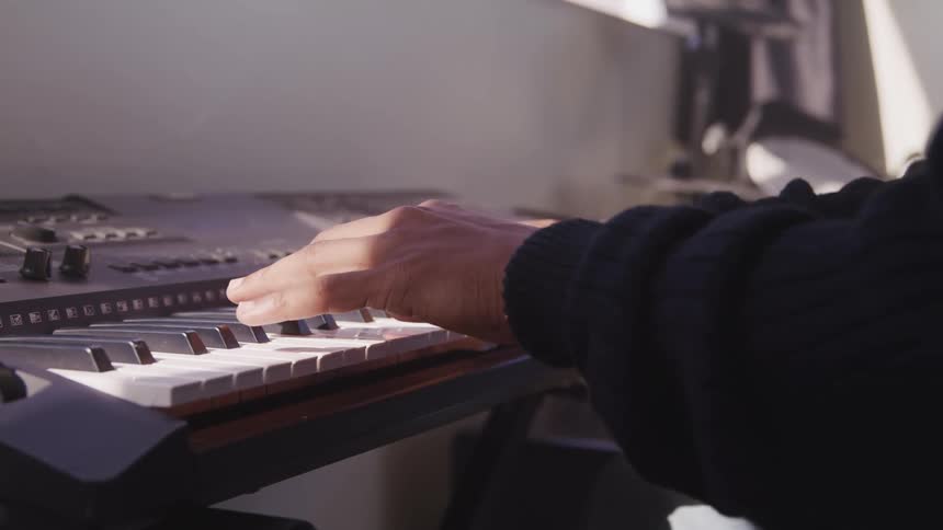 A man is playing a piano indoors