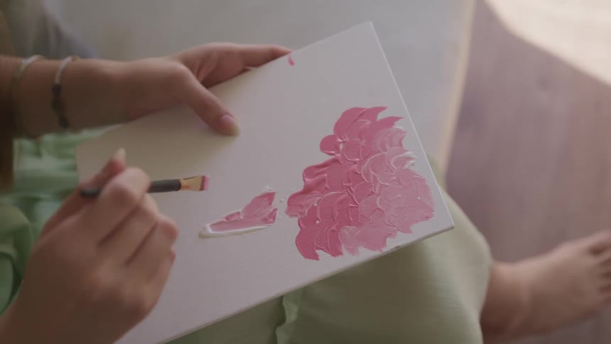 A woman is painting with pink paint