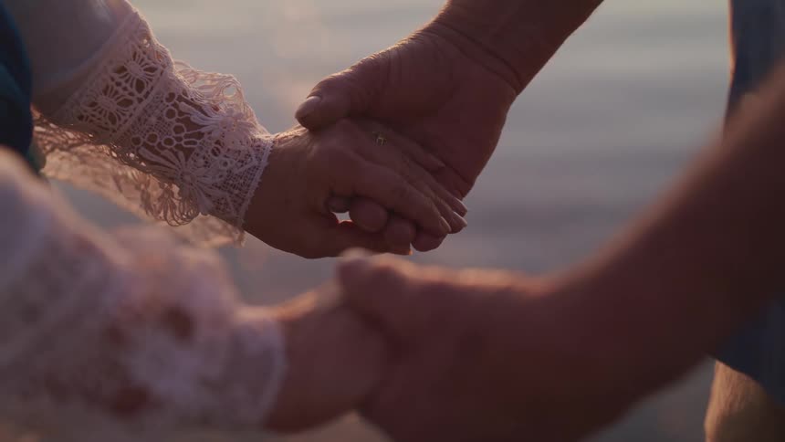 Man and woman face each other and hold each others hands