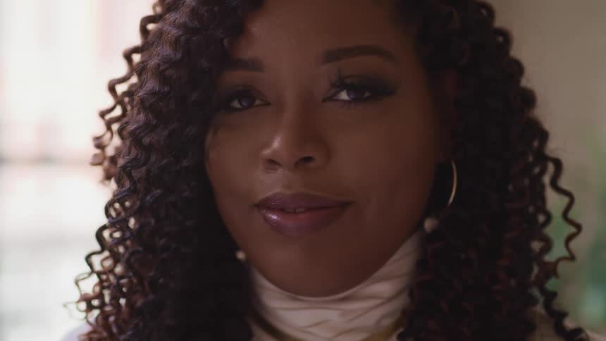 Black woman with wavy hair blinks her eyes