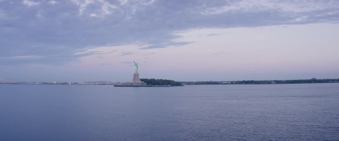 The statue of liberty stands in the distance