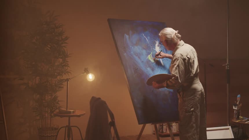 A man is painting a picture indoors