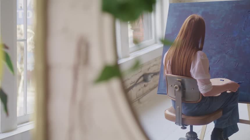 A woman painting on a large easel