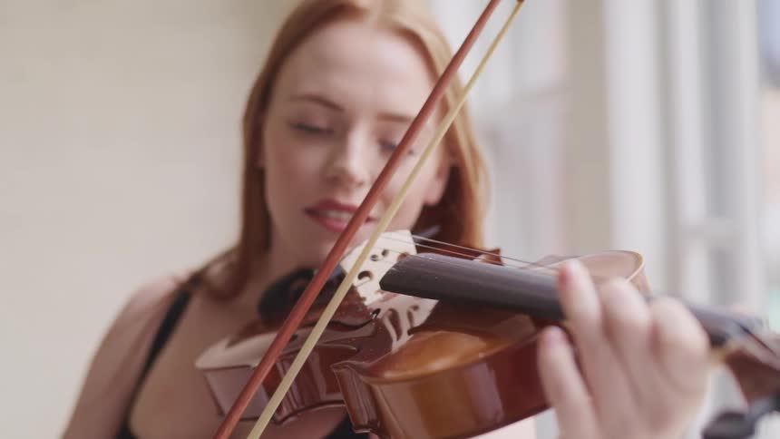 Woman with long hair plays the violin