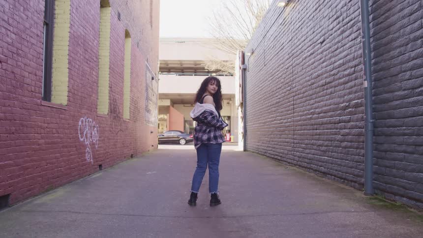 A woman is standing in the empty alley
