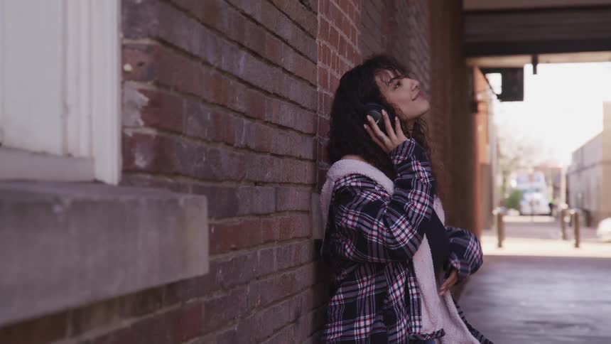 A woman is listening to music outdoors