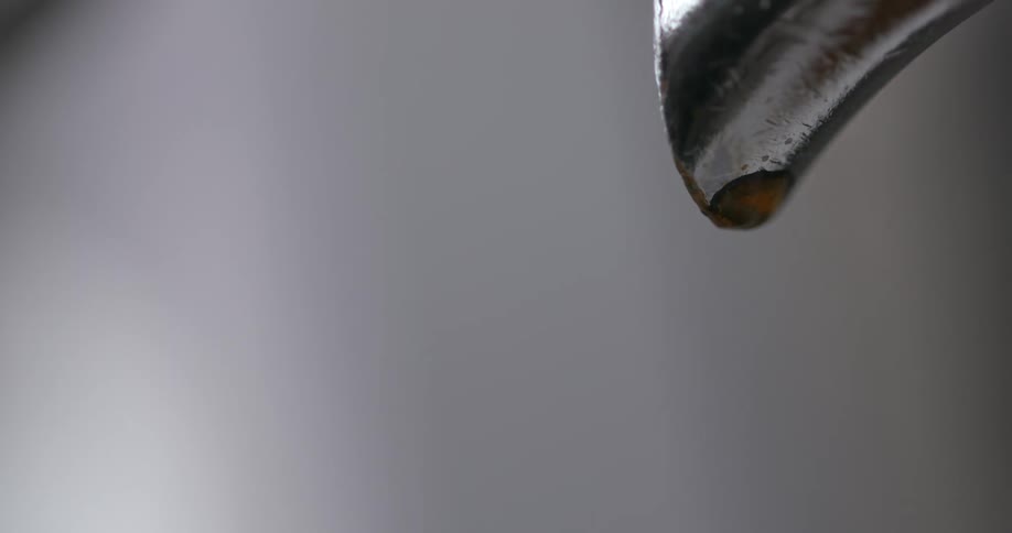 Coffee drips from a metal spout