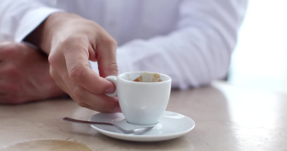 A man is taking a drink in the cafe