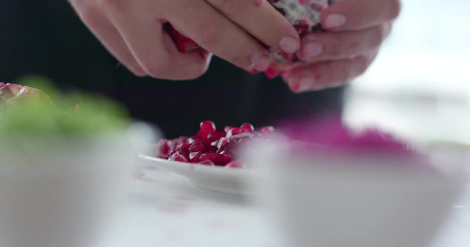 A person is opening a pomegranate