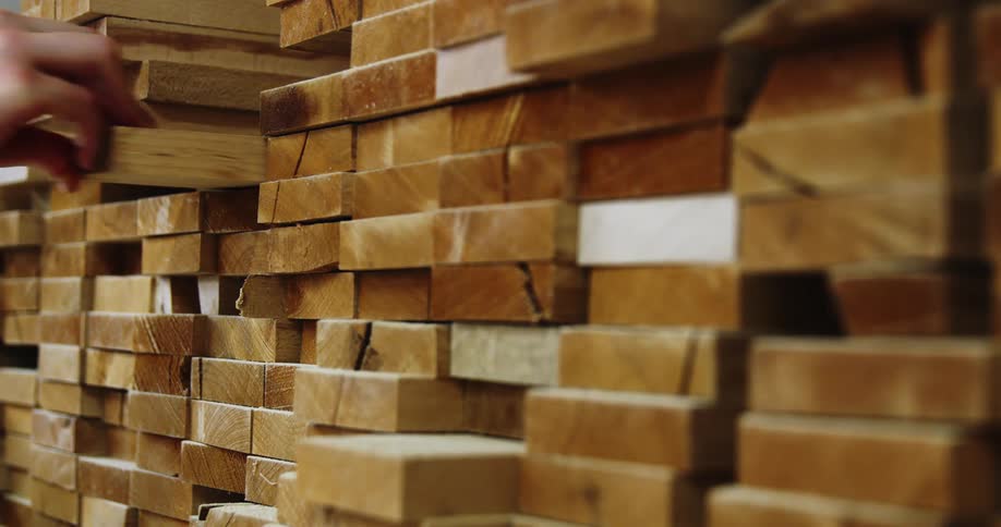 Person adds board to large wide stack of boards