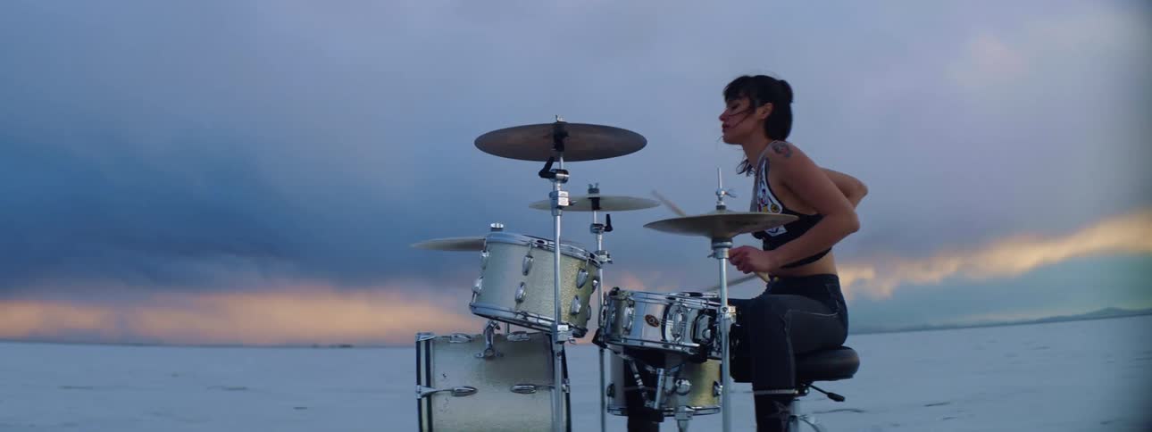 A woman is playing drums on the field