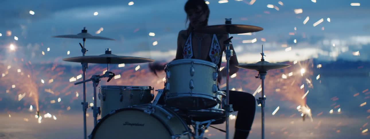 A female playing the drums outside