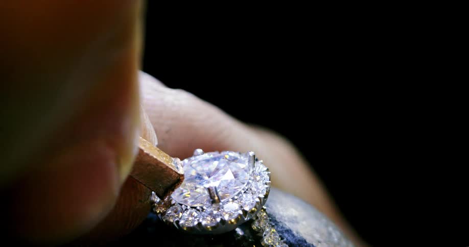 A jeweler sets a diamond in a ring