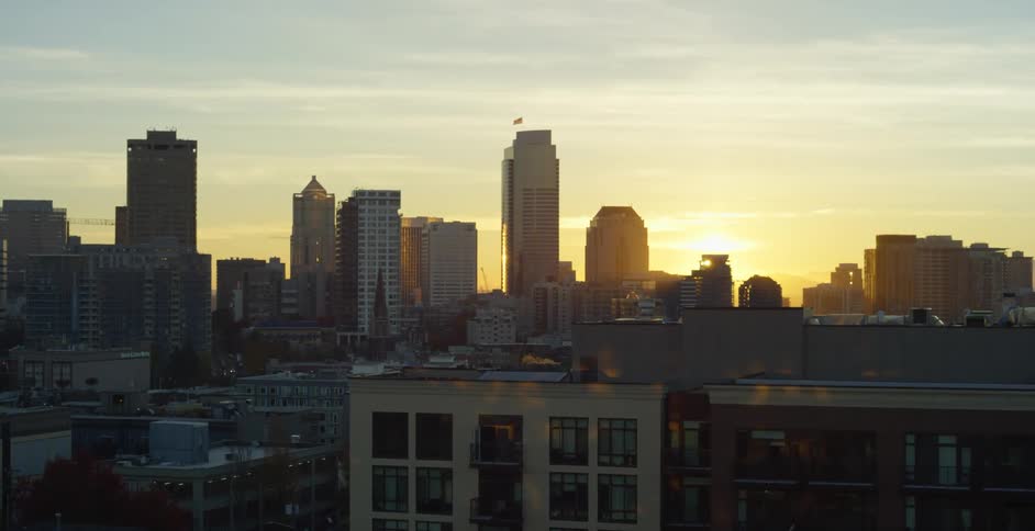 An aerial view of a downtown city at dusk is displayed