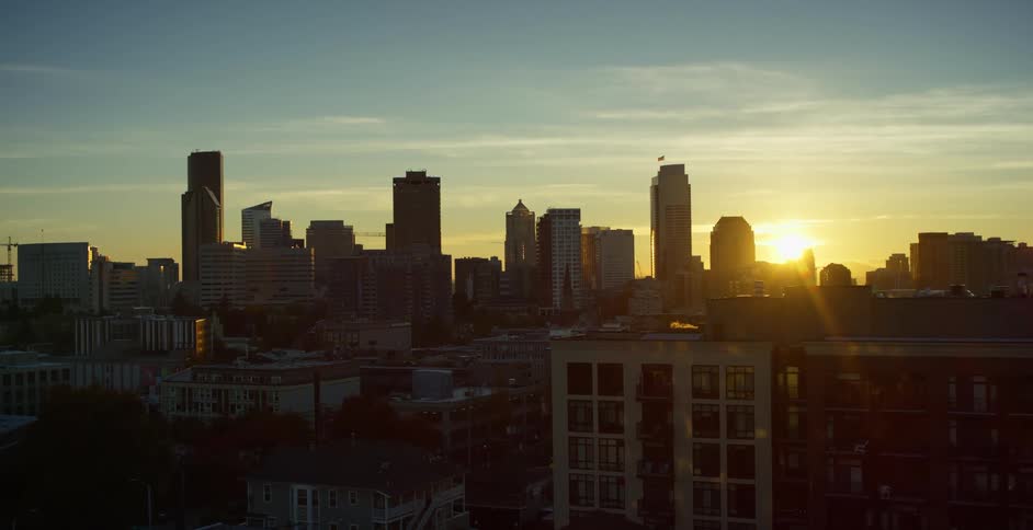 The sun sets over a downtown city