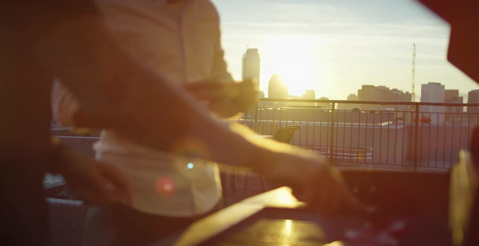 Two men on a rooftop grilling food