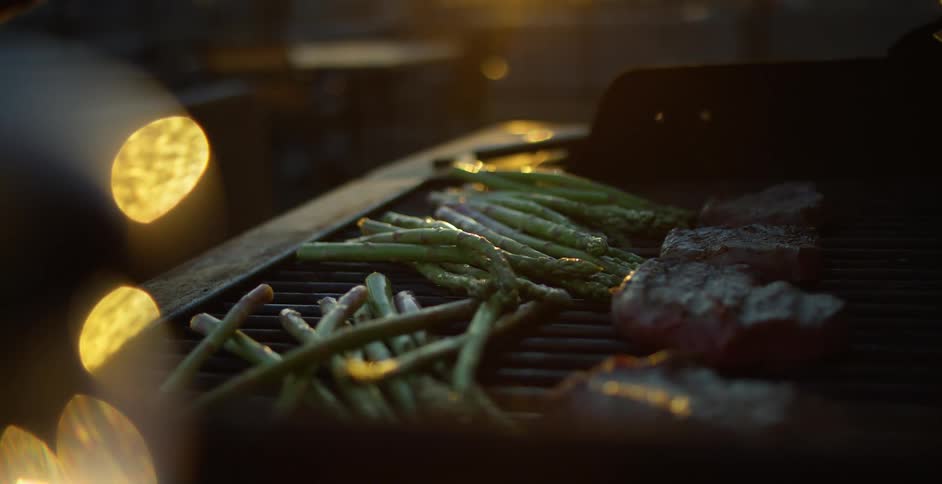Steaks and green beans on the grill outdoors at night