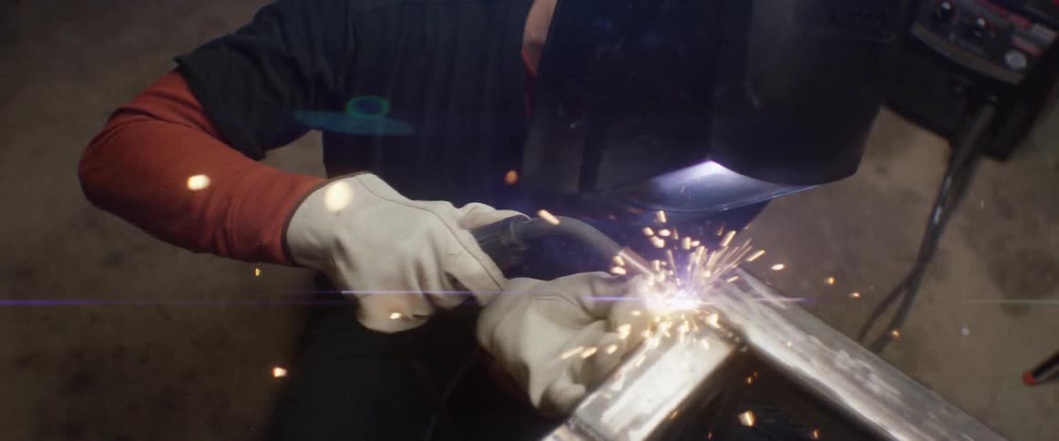 A man is using a blow torch to weld metal