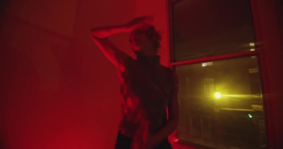 A woman dancing in a room with red lighting