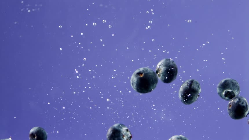 Blueberries fall in the water