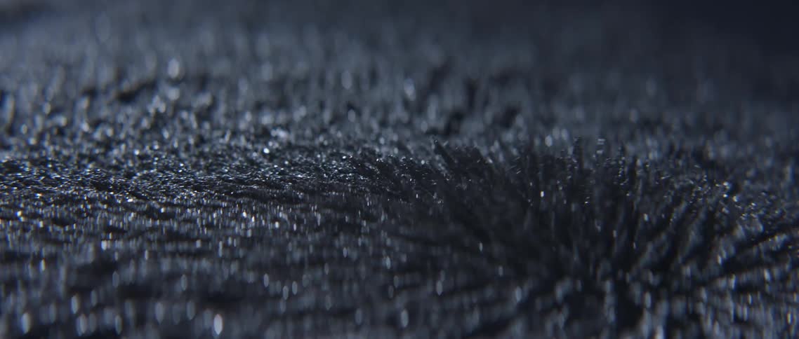 Close up of iron filings moving and reacting to a magnetic field