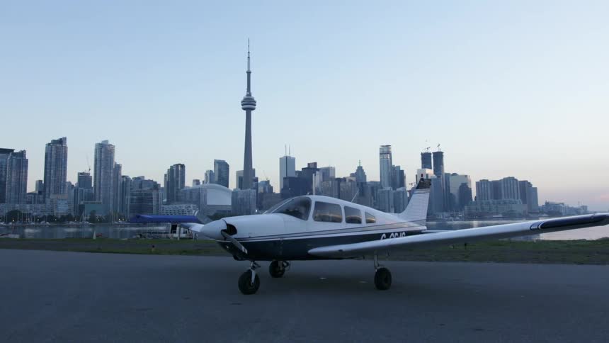 Small private airplane sits in front of toronto city skyline