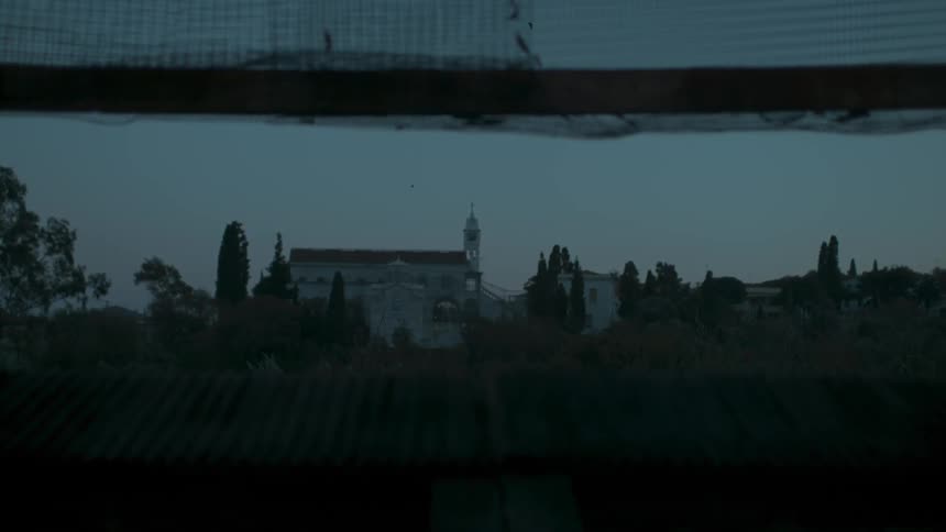 Dark view of a large mansion that is waterside