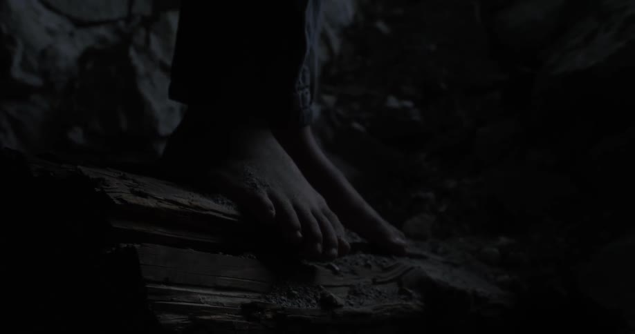 Bare feet stand on rocky ground