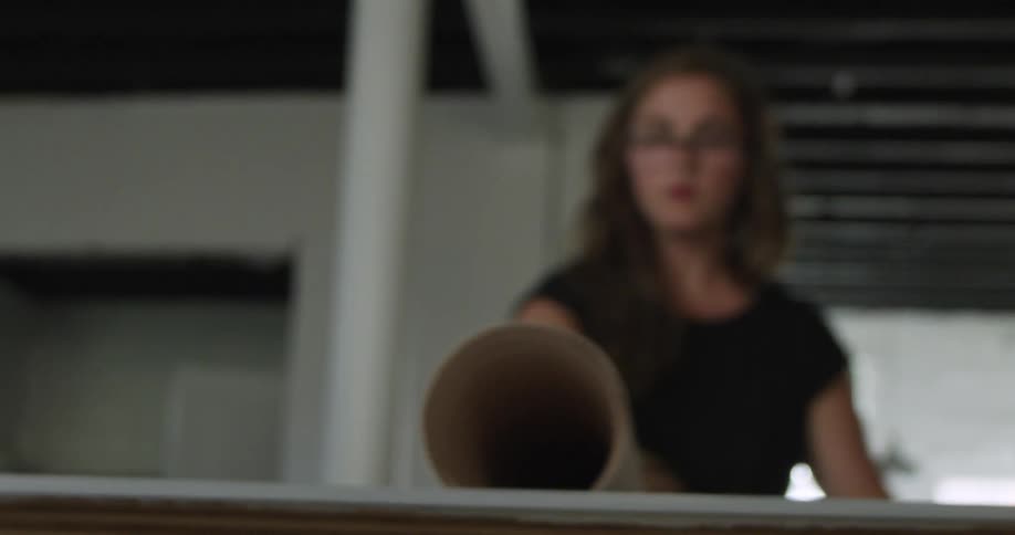 Woman unrolling paper on a large table