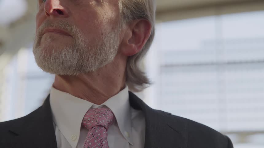 Close up of a bearded man wearing a suit and tie
