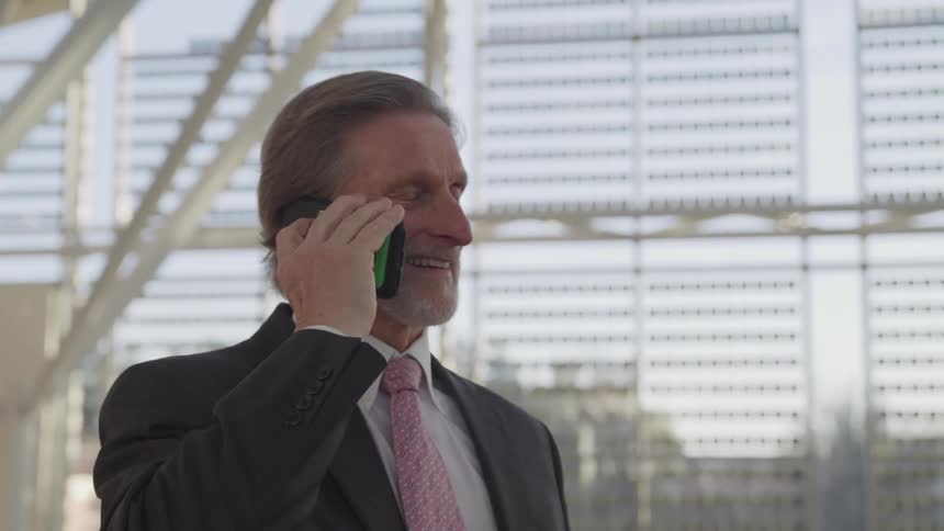 A man is talking on a cell phone downtown