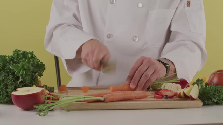 A chef chopping carrots