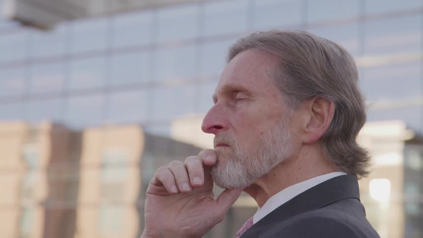 A man is standing outdoors in a downtown city