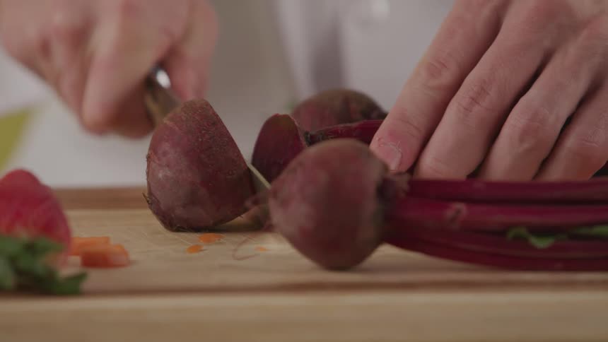 A chef is cutting up a radish