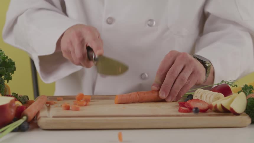A chef cuts up a carrot