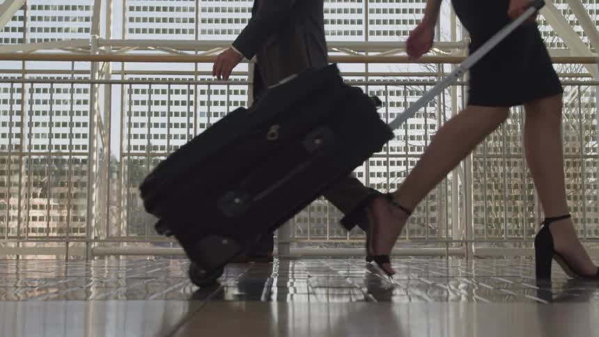 People carrying baggage walk inside a terminal