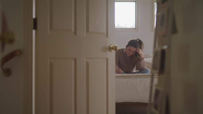Woman reading while sitting in bed in the bedroom at home