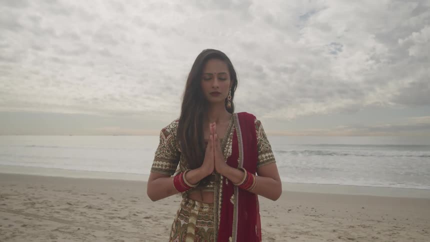 A woman praying on the shore