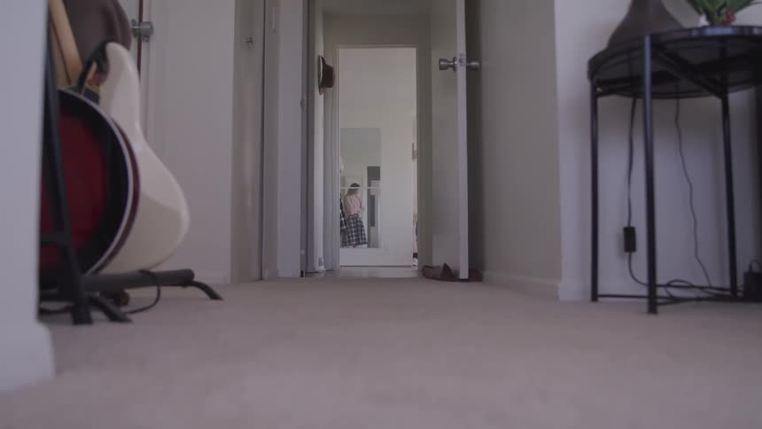 A girl paces back and worth in a hallway