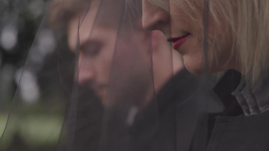 Close up of people wearing black clothes in a funeral at a cemetery