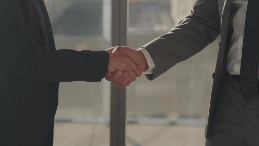 Two men in an office shake hands