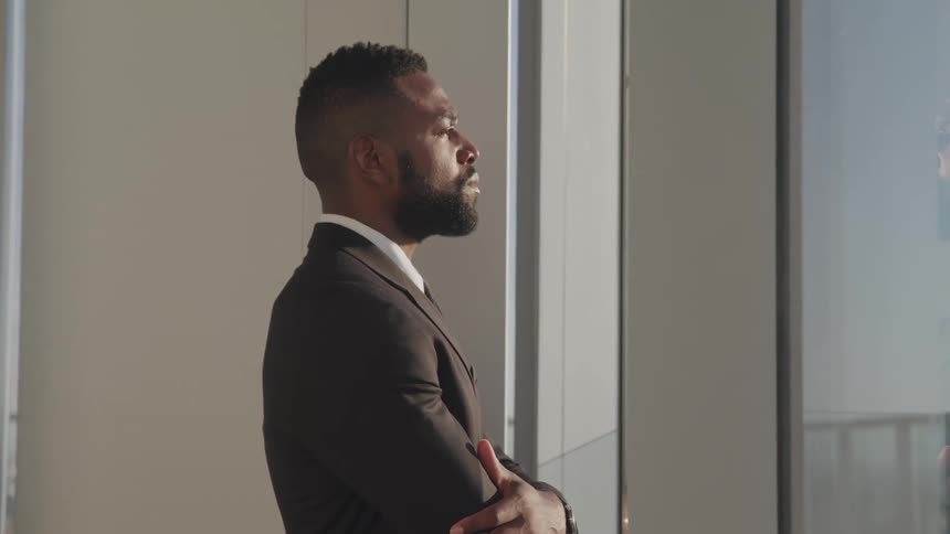 A man standing and looking out his office window