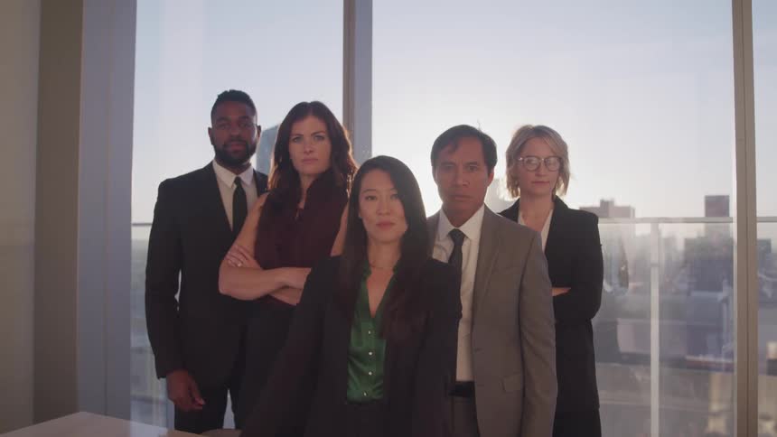 Group of business people standing in an office looking at the camera