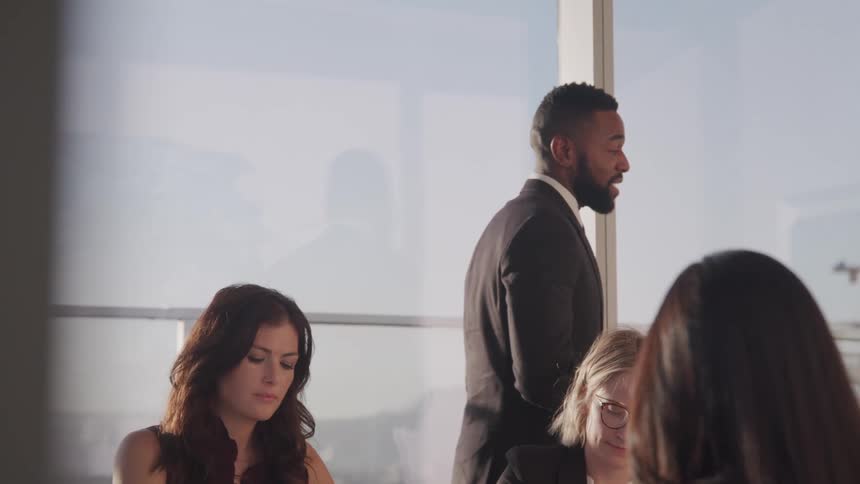 A small group of business people conducts a meeting in conference room