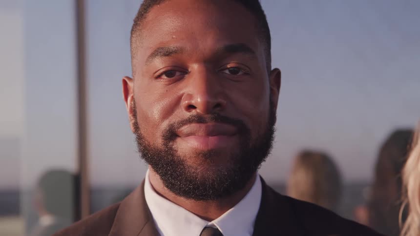 A man is standing outside smiling