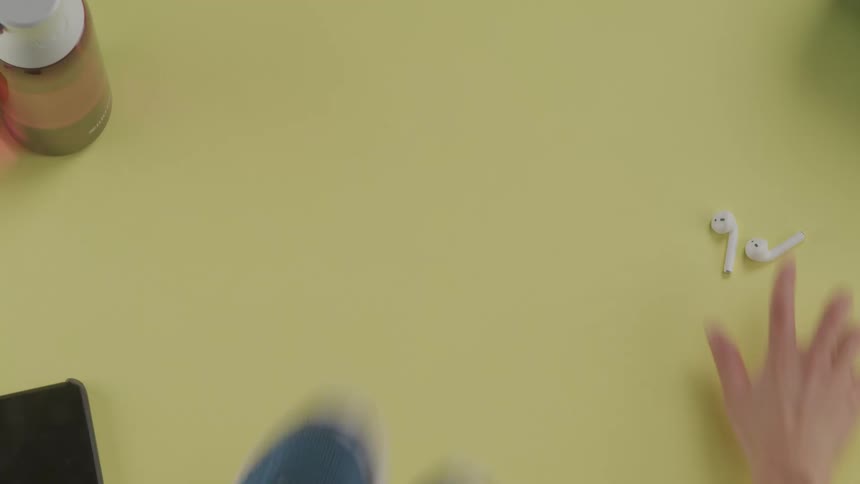 A woman grabs her running shoes and air pods